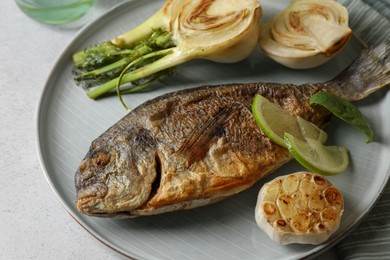 Photo of Delicious dorado fish with vegetables served on table, closeup