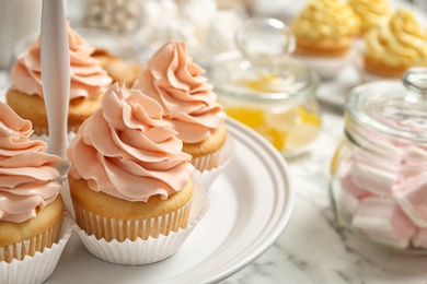 Photo of Stand with tasty cupcakes on table, space for text. Candy bar