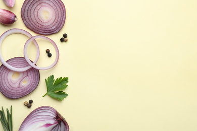 Photo of Flat lay composition with onion and spices on beige background. Space for text