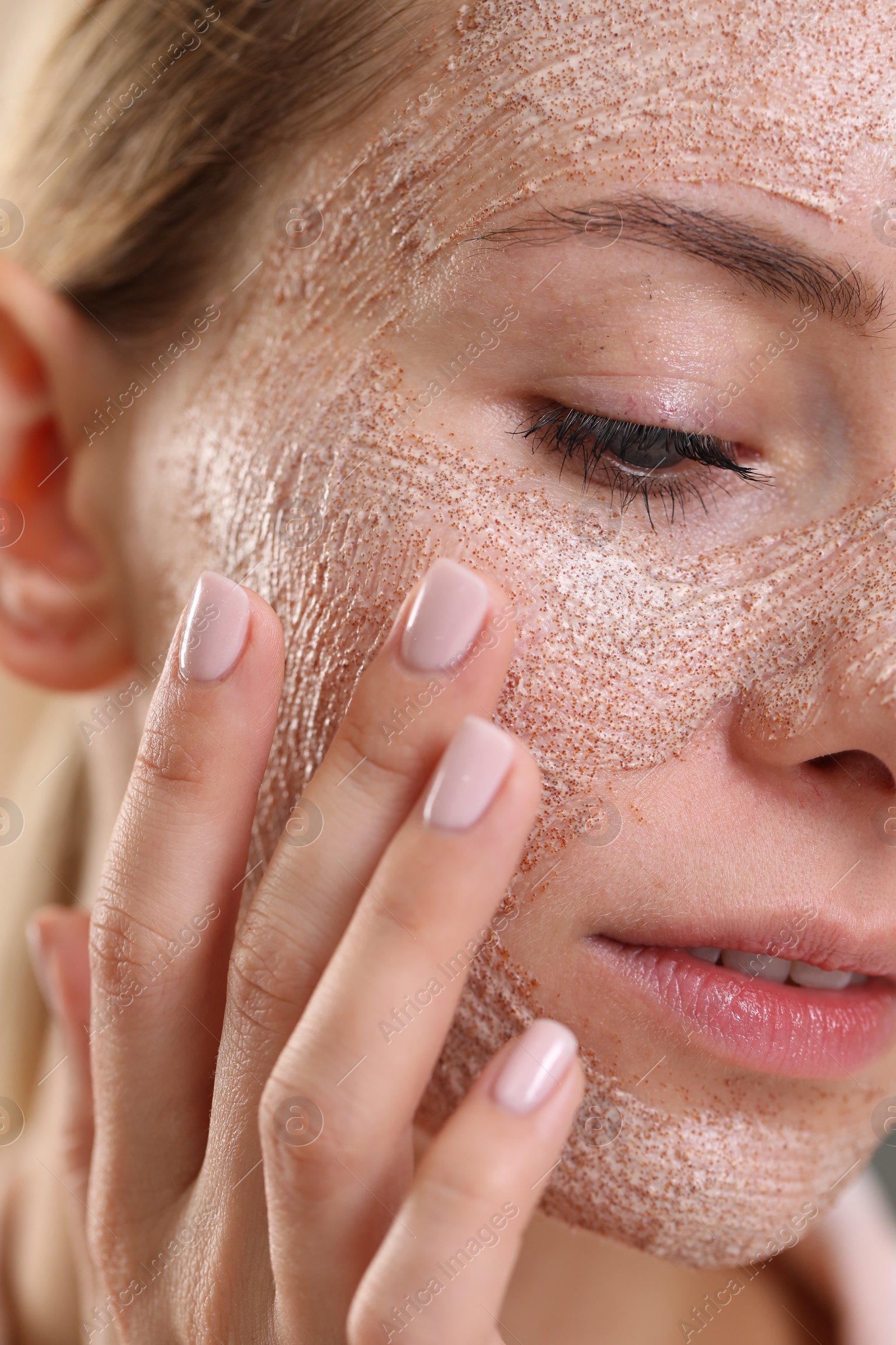 Photo of Woman applying face mask, closeup. Spa treatments