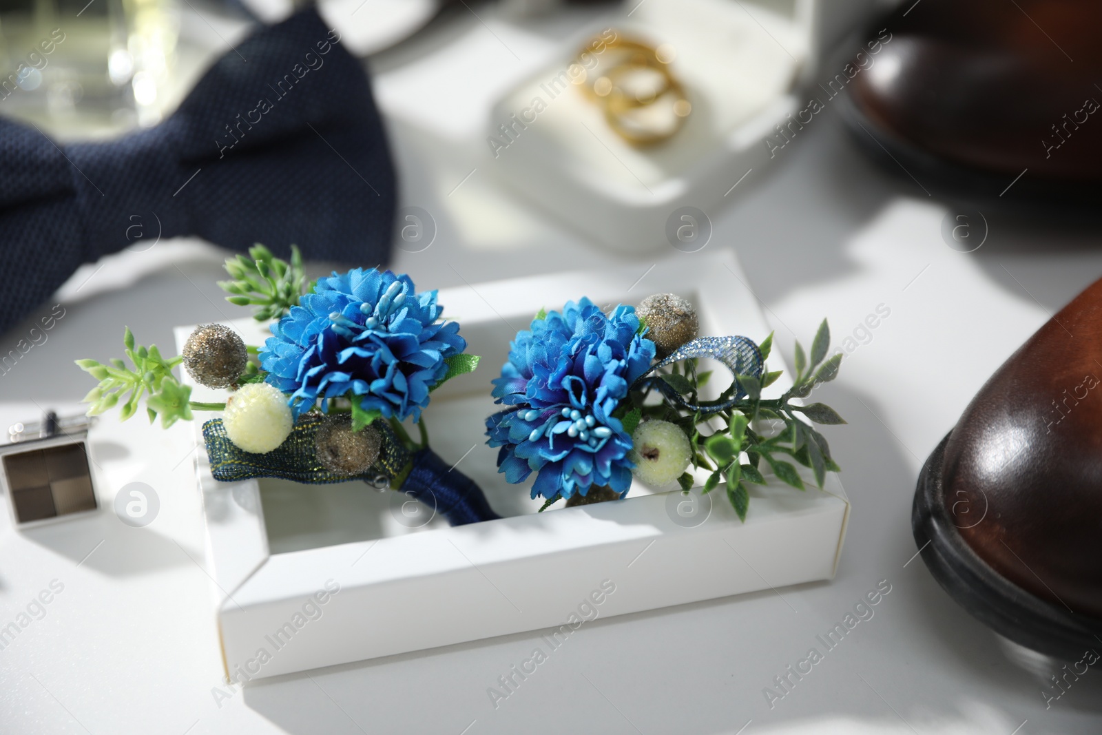 Photo of Wedding stuff. Composition with stylish boutonniere on white background, closeup