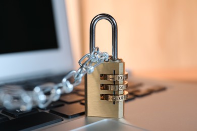 Photo of Cyber security. Padlock with chain on laptop, closeup