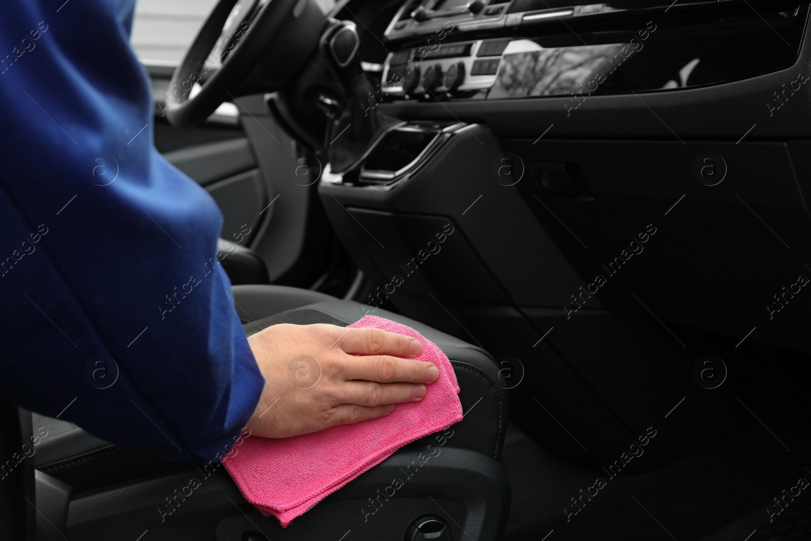 Photo of Car wash worker cleaning automobile interior, closeup