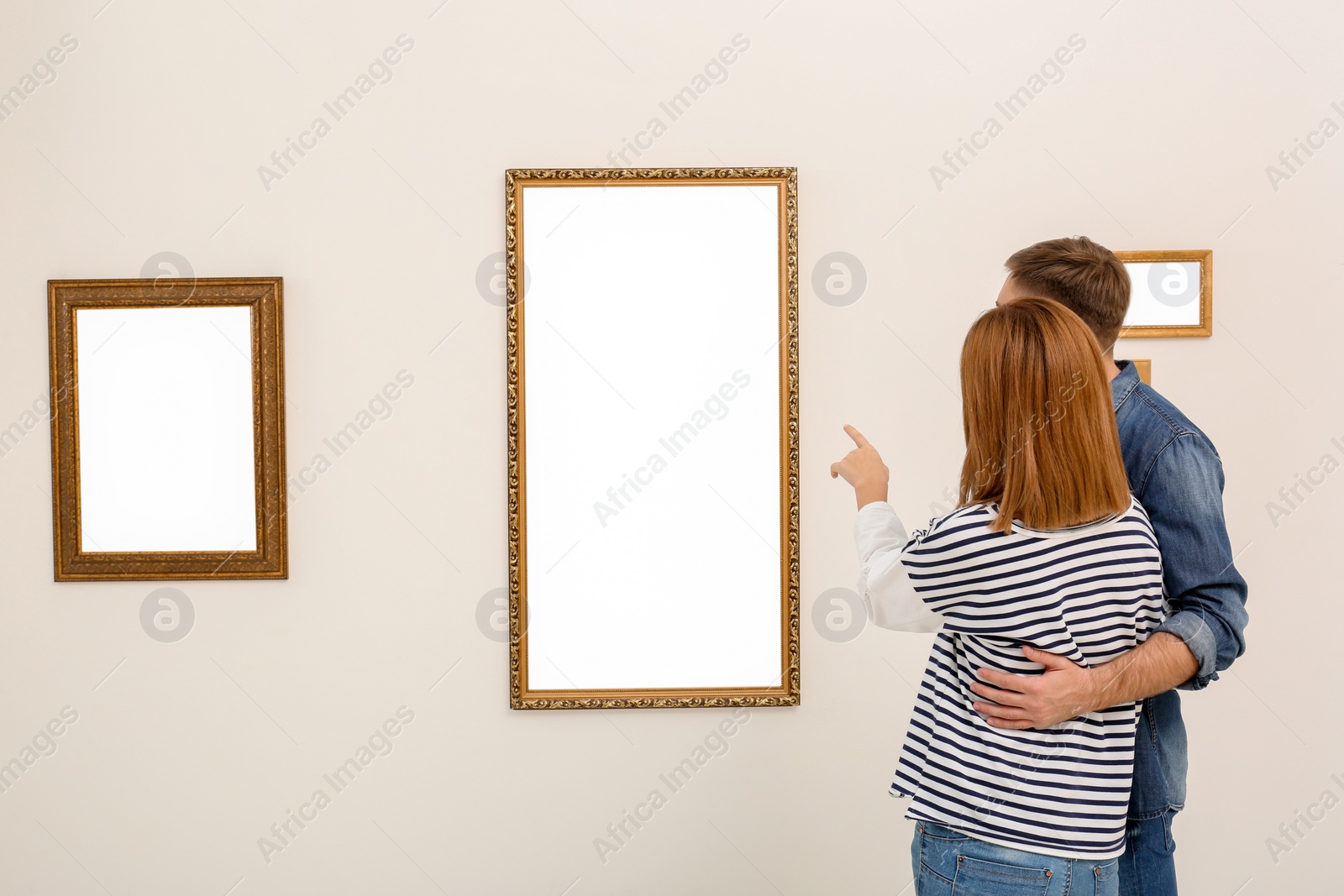 Photo of Couple viewing exposition in modern art gallery