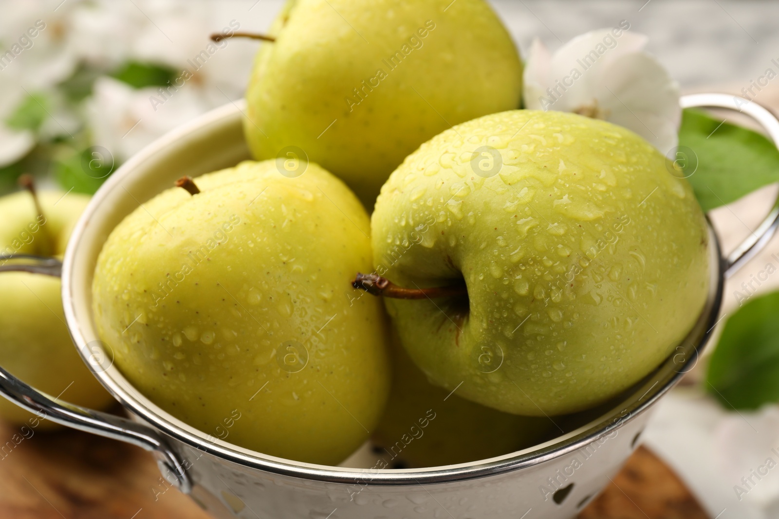 Photo of Colander with fresh wet apples on table, closeup