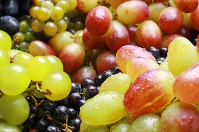 Photo of Fresh ripe juicy grapes with water drops as background, closeup