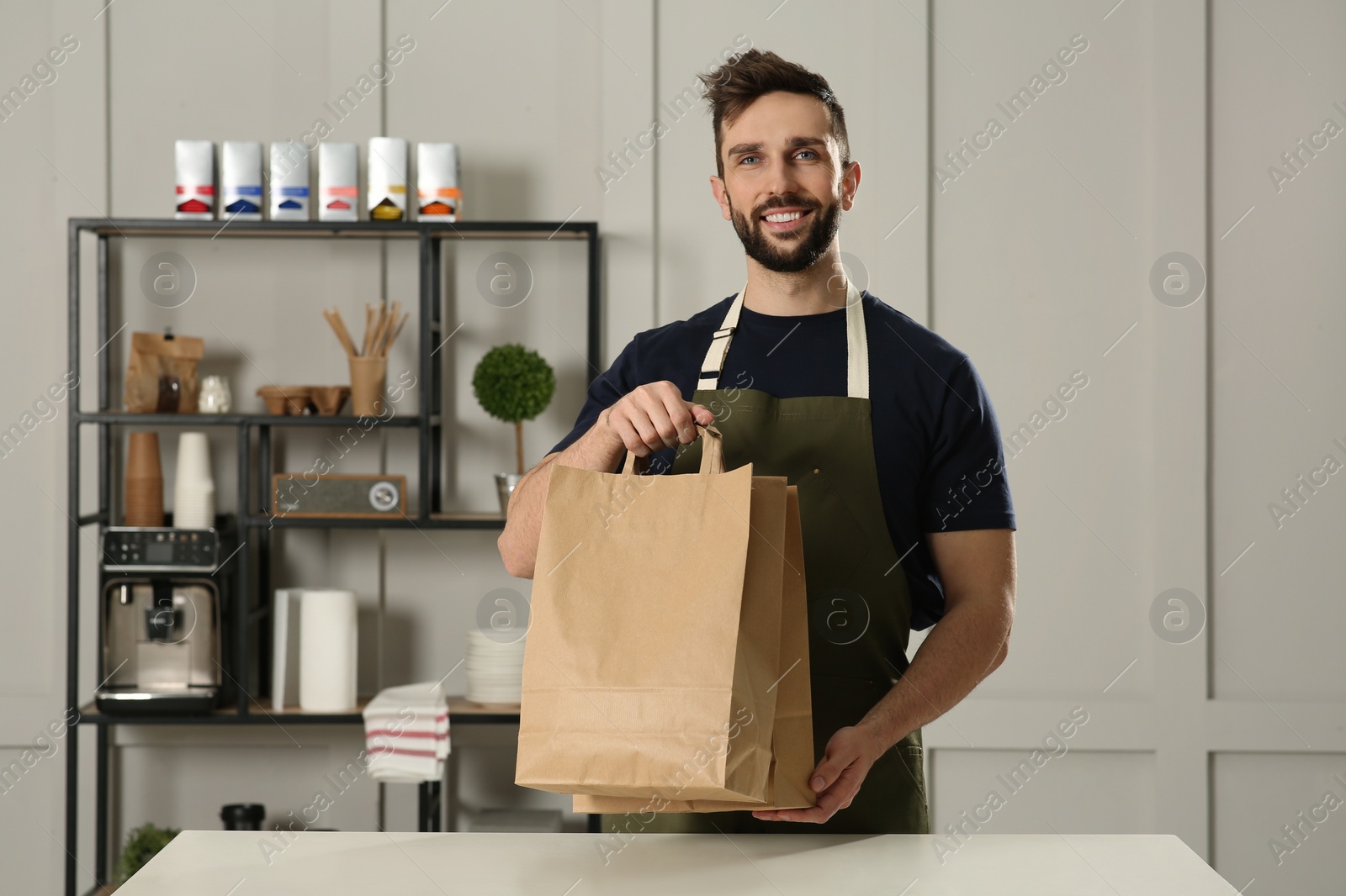 Photo of Worker with paper bags at counter in cafe