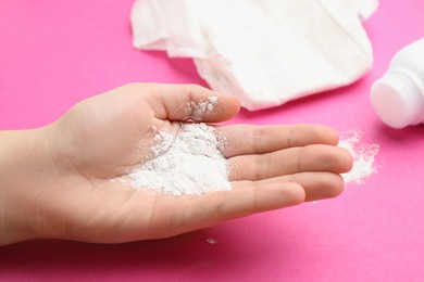 Woman with dusting powder on pink background, closeup