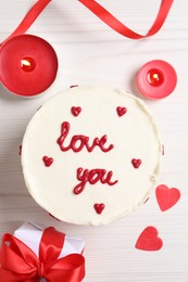 Bento cake with text Love You, gift box, candles and paper hearts on white wooden table, flat lay. St. Valentine's day surprise