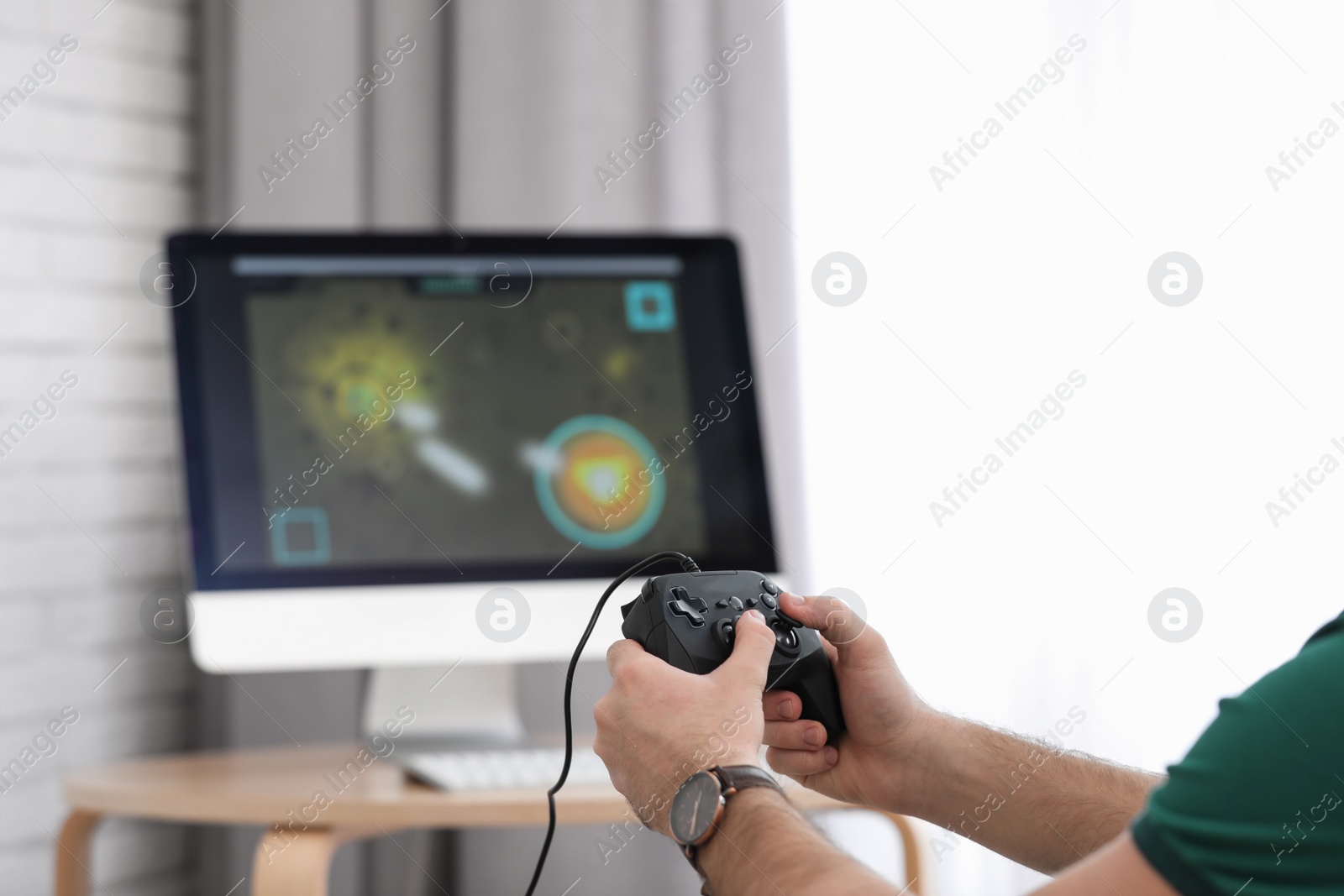 Photo of Young man playing video game at home, closeup