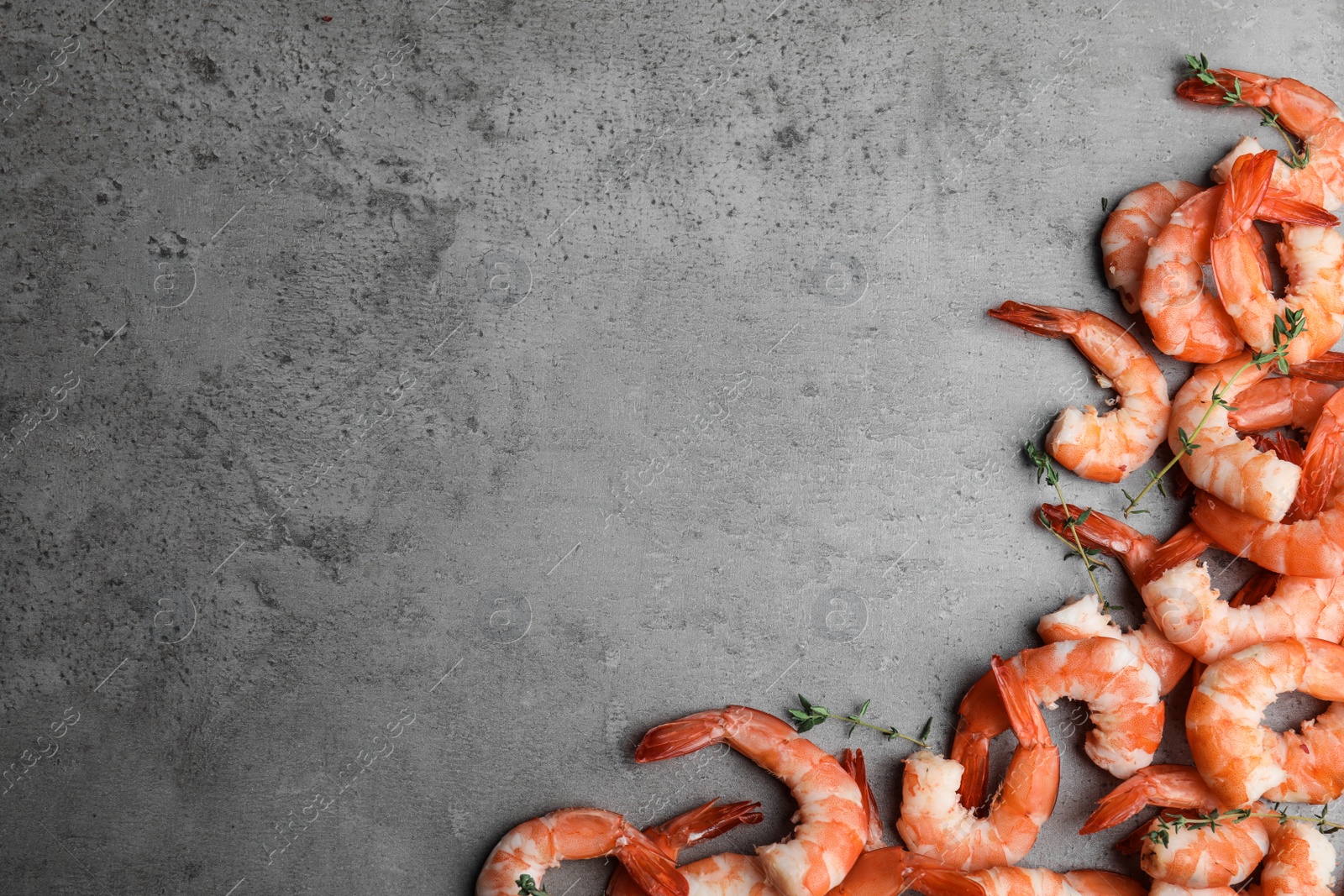 Photo of Tasty boiled shrimps with thyme on grey table, flat lay. Space for text