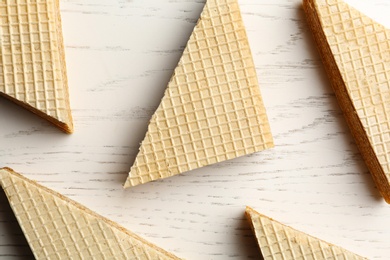 Photo of Delicious crispy wafers on white wooden table, flat lay