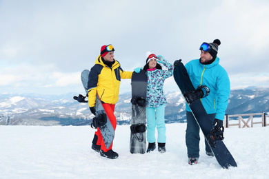 Group of friends with equipment in snowy mountains. Winter vacation