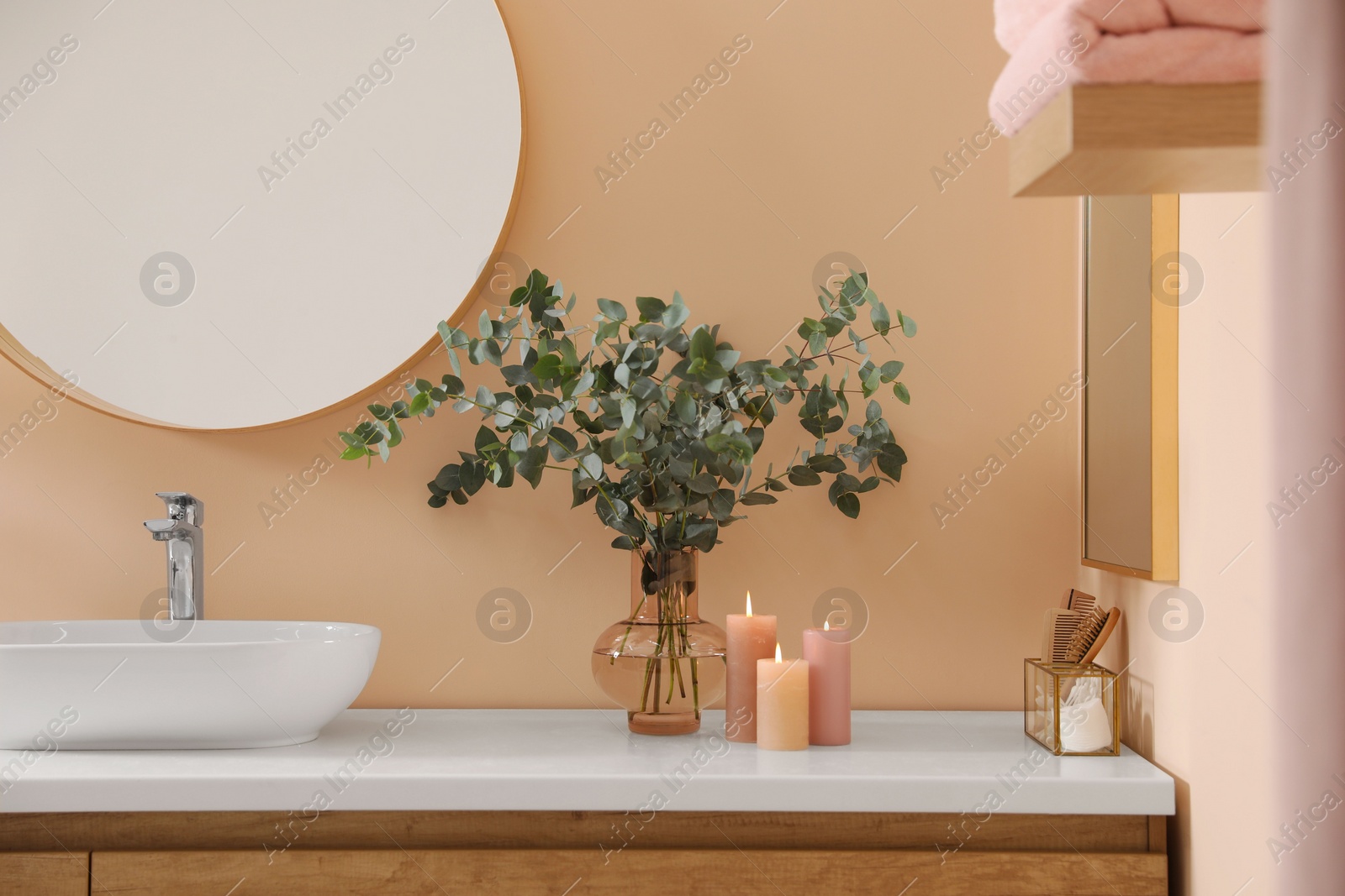 Photo of Stylish mirror, eucalyptus branches and vessel sink in modern bathroom. Interior design