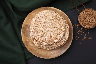 Photo of Crunchy buckwheat cakes and cereal on black table, flat lay