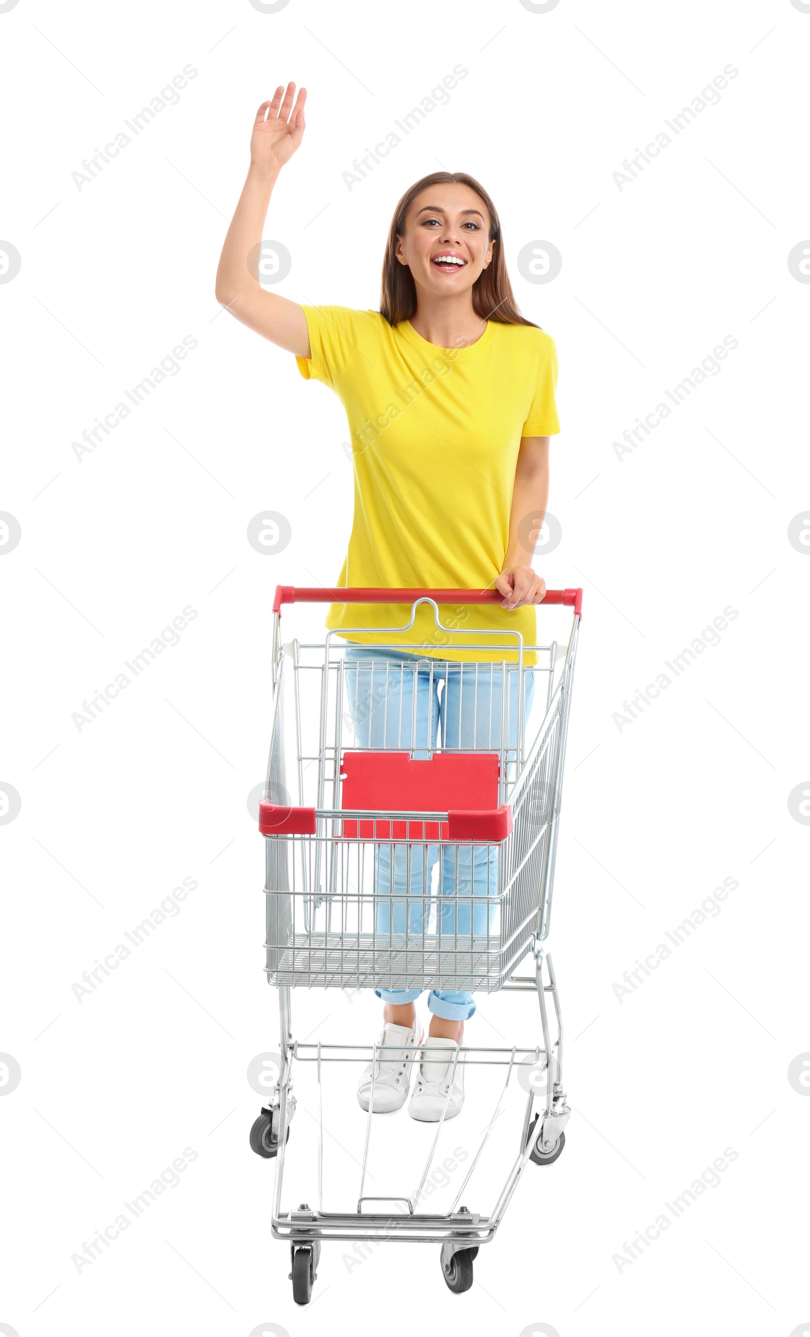 Photo of Young woman with empty shopping cart on white background