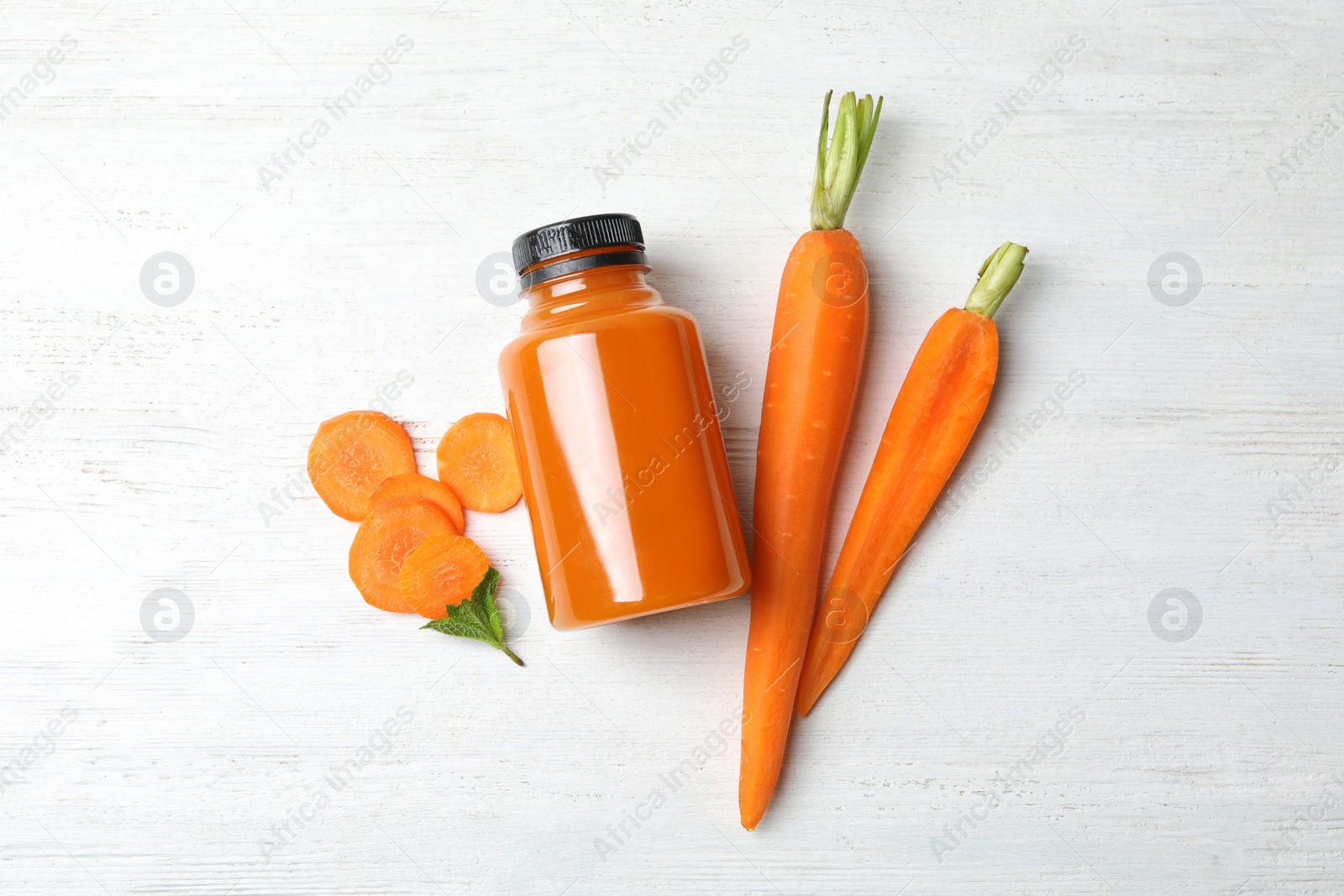 Photo of Flat lay composition with carrots and juice on white wooden table
