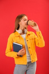 Photo of Teenage student with book drinking coffee on red background
