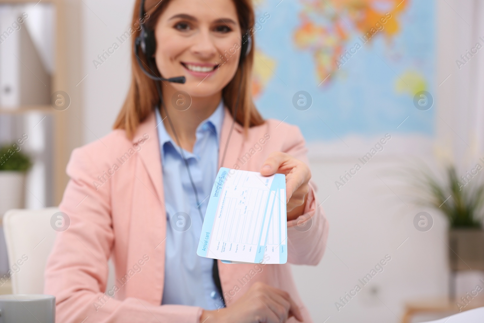 Photo of Beautiful consultant holding tickets in travel agency