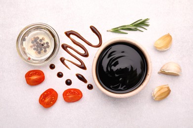 Photo of Organic balsamic vinegar and cooking ingredients on white table, flat lay