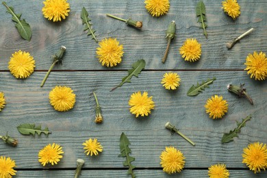Photo of Flat lay composition with beautiful yellow dandelions on blue wooden table