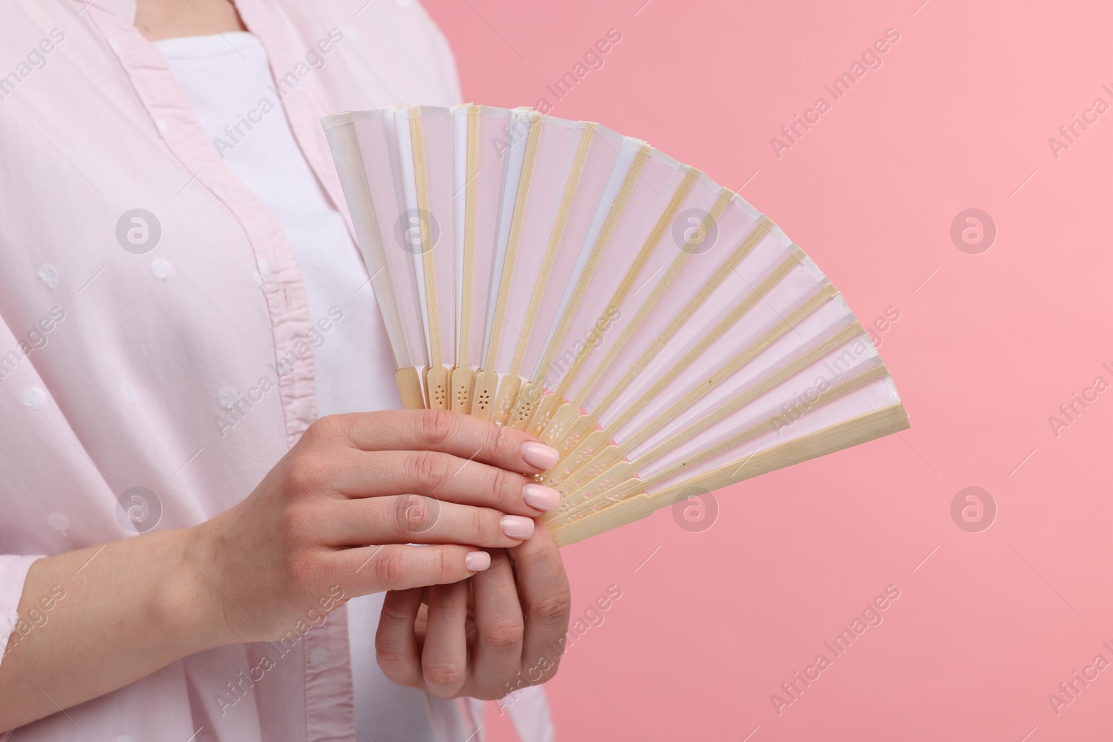 Photo of Woman with hand fan on pink background, closeup