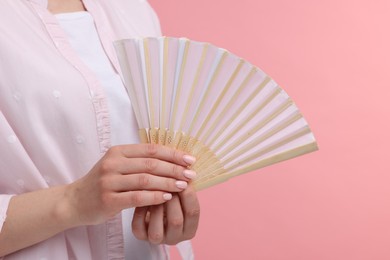 Photo of Woman with hand fan on pink background, closeup