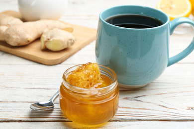 Photo of Tasty honey with combs and drink on white wooden table