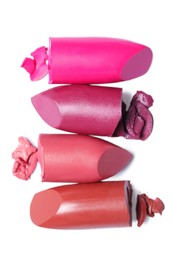 Many different bright lipsticks on white background, top view