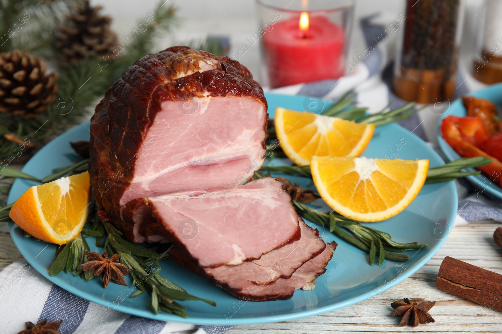 Photo of Plate with delicious ham, rosemary and orange on white wooden table. Christmas dinner