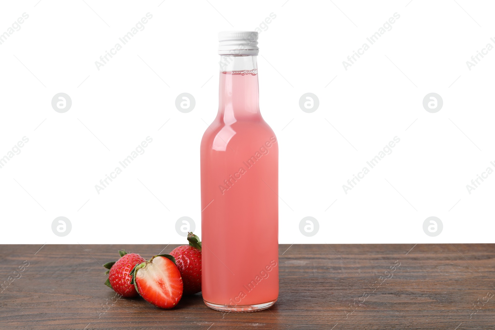 Photo of Delicious kombucha in glass bottle and strawberries on wooden table against white background