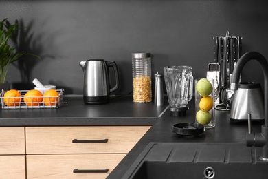 Photo of Stylish kitchen counter with houseware, appliances and products