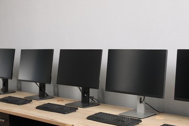 Open office interior. Modern workplaces with computers near light grey wall