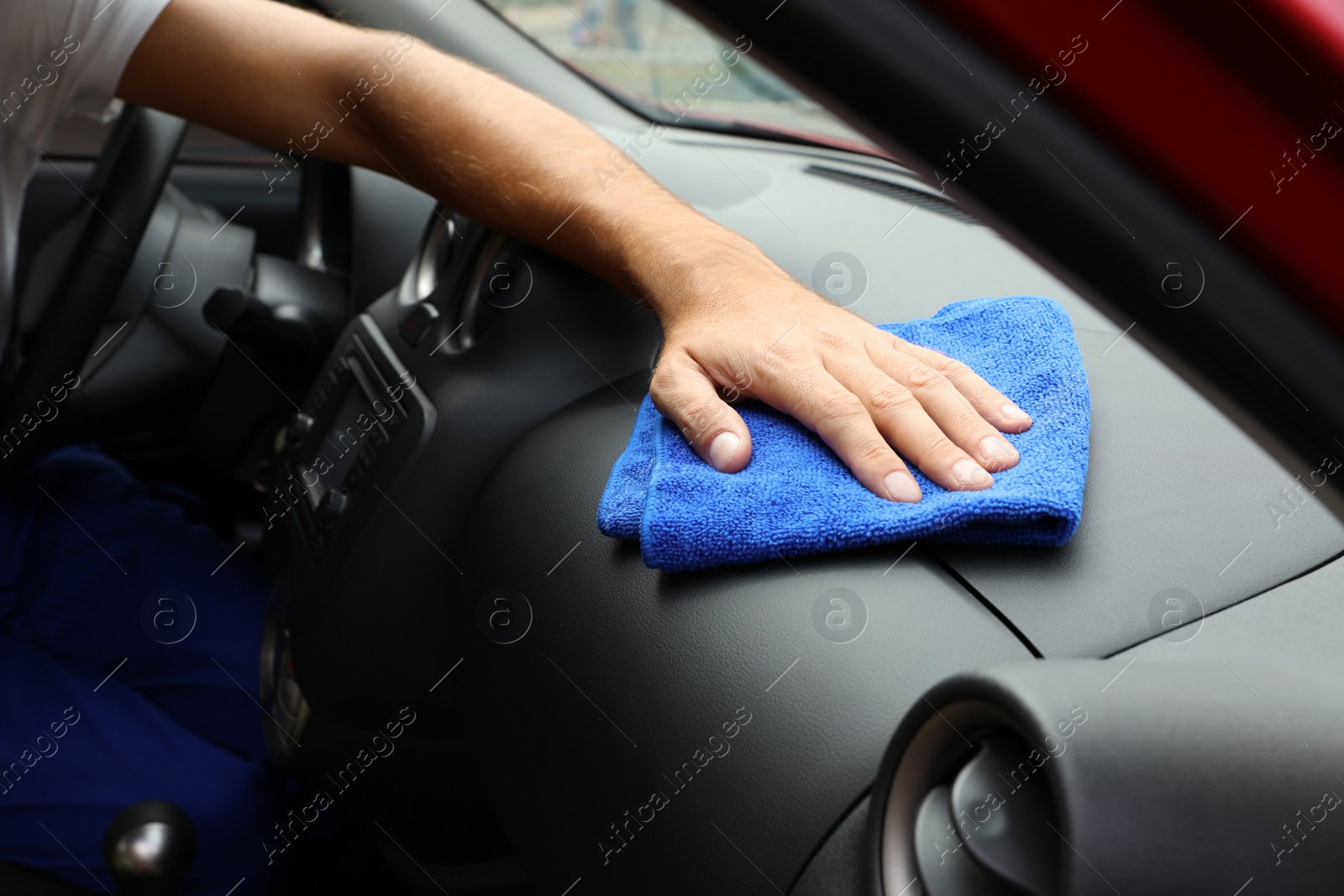 Photo of Man cleaning automobile dashboard with duster, closeup. Car wash service