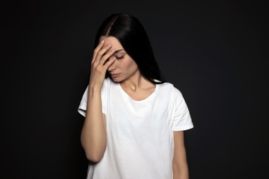 Photo of Portrait of upset young woman on dark background