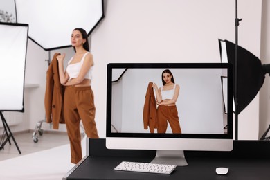 Photo of Beautiful model posing in modern photo studio, focus on computer screen with picture
