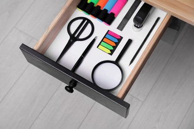 Office supplies in open desk drawer, above view