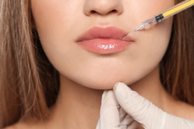 Photo of Young woman getting lips injection, closeup. Cosmetic surgery