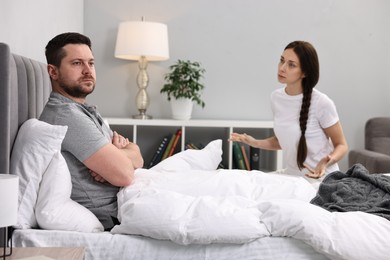 Photo of Offended husband ignoring his wife in bed. Relationship problems