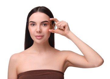 Beautiful young woman holding skincare ampoule on white background