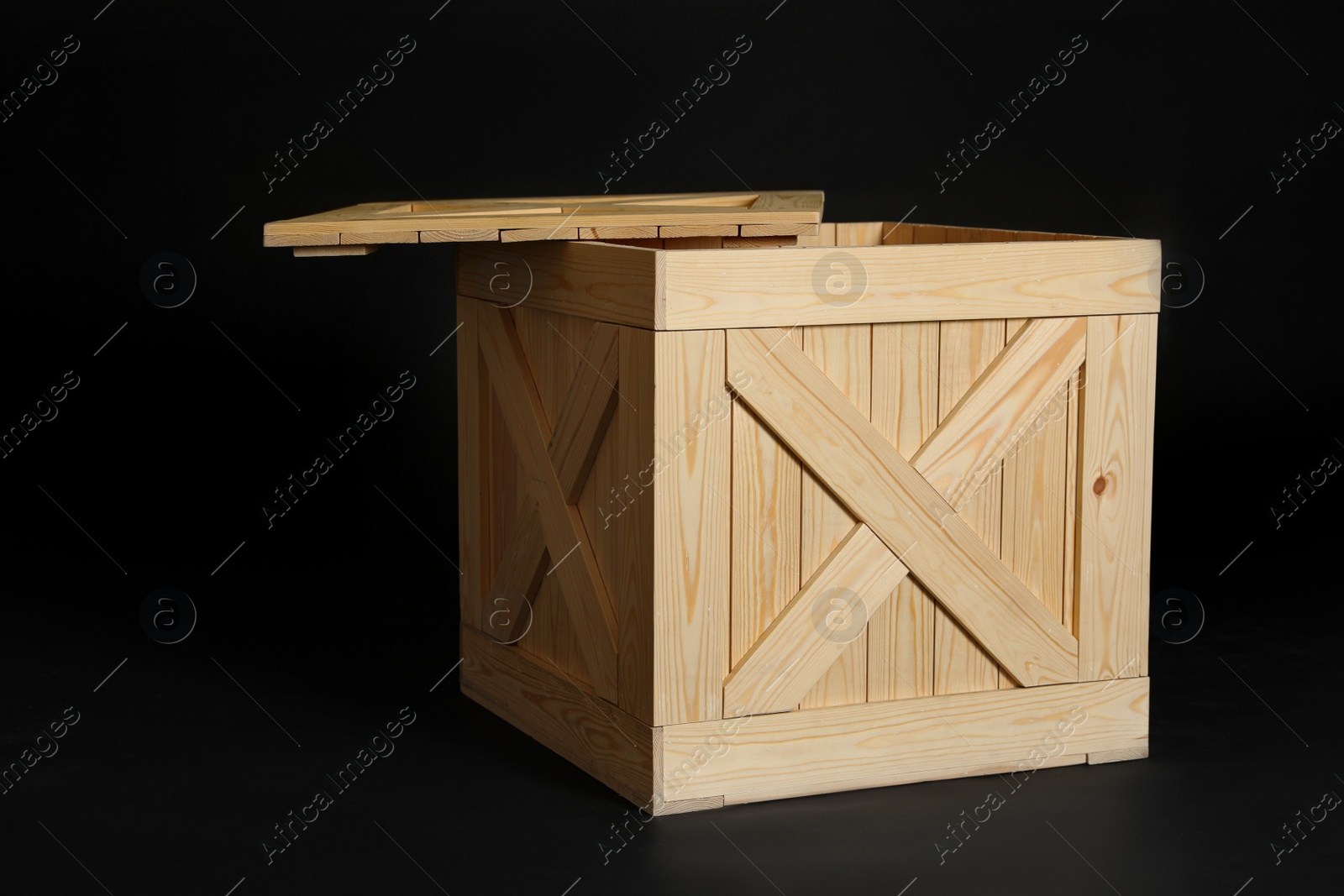 Photo of Wooden crate on black background. Space for text