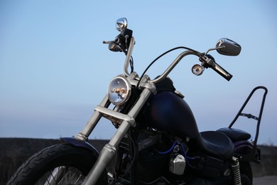 Photo of Modern black motorcycle against blue sky outdoors