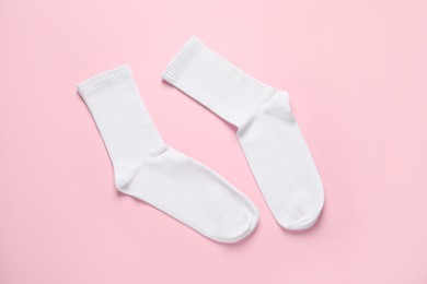 Pair of white socks on pink background, flat lay