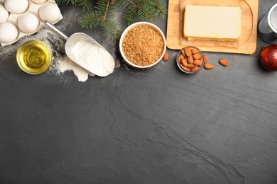 Photo of Flat lay composition with ingredients for traditional Christmas cake on grey table. Space for text