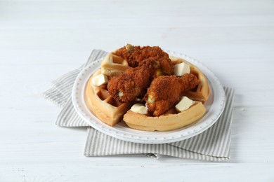 Delicious Belgium waffles served with fried chicken and butter on white table, closeup