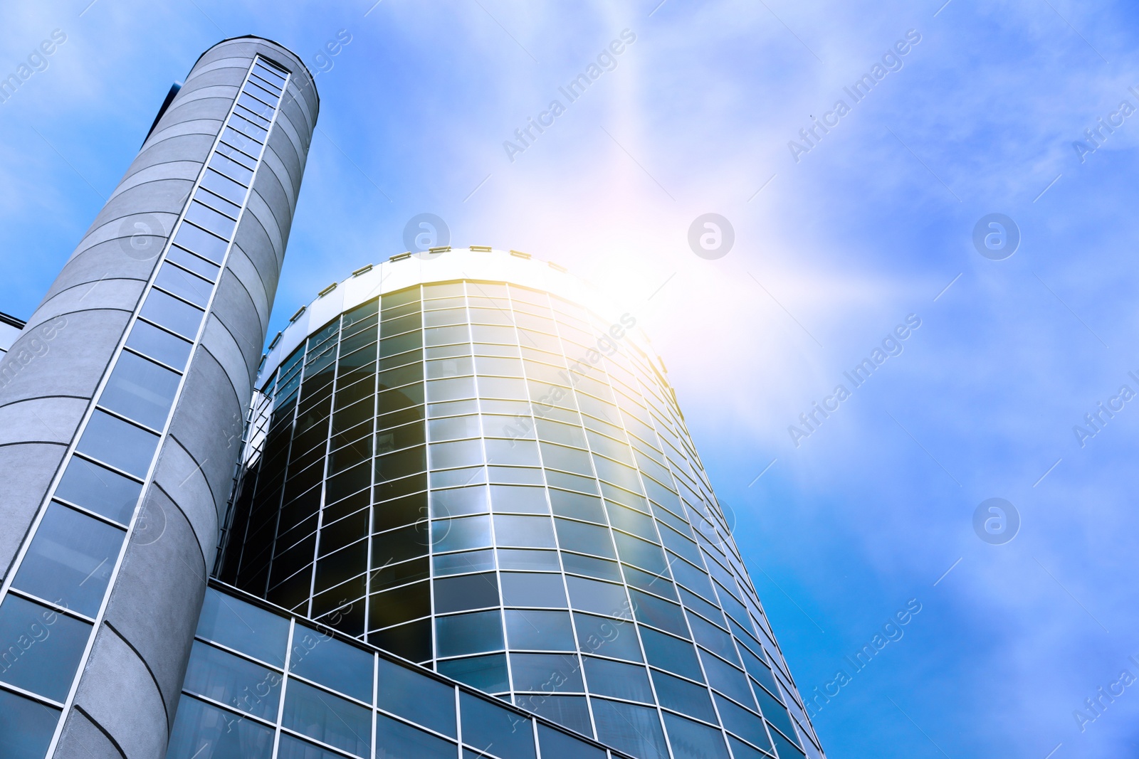 Image of Modern skyscraper with tinted windows against blue sky, low angle view. Building corporation