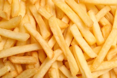 Photo of Many delicious French fry pieces as background