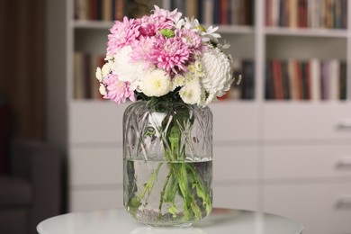 Photo of Bouquet of beautiful chrysanthemum flowers on white table indoors