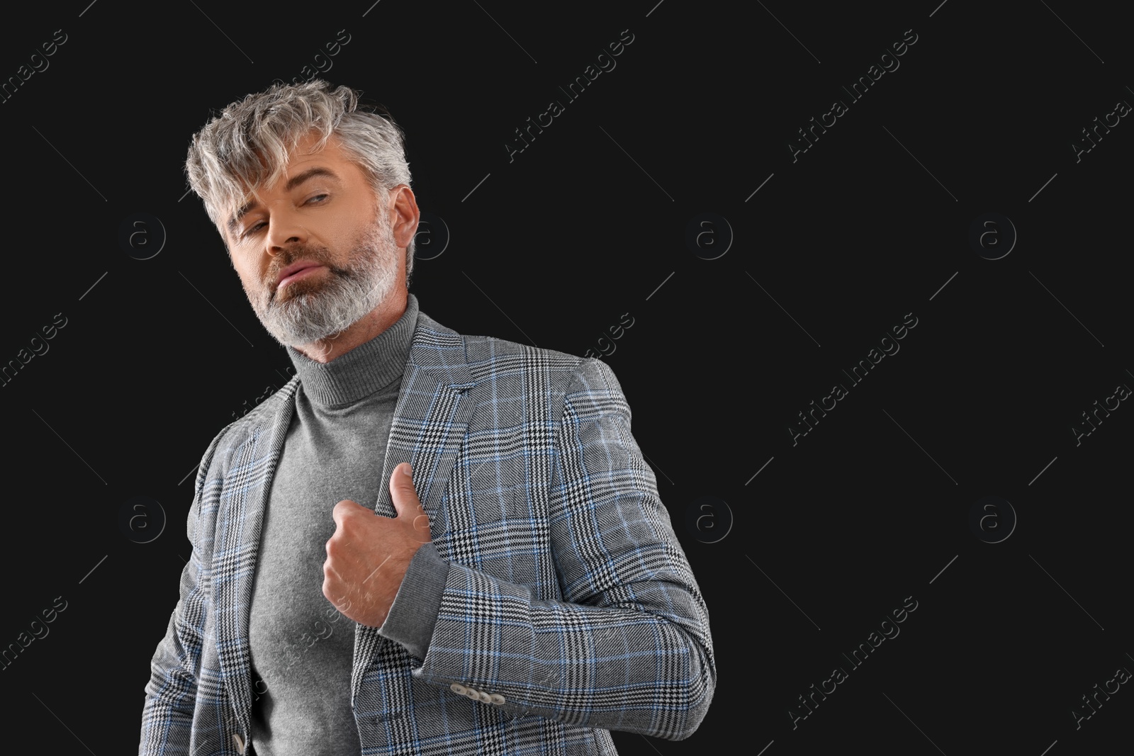 Photo of Portrait of confident man with beautiful hairstyle on black background. Space for text