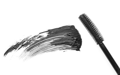 Photo of Smear of black mascara and applicator isolated on white, top view